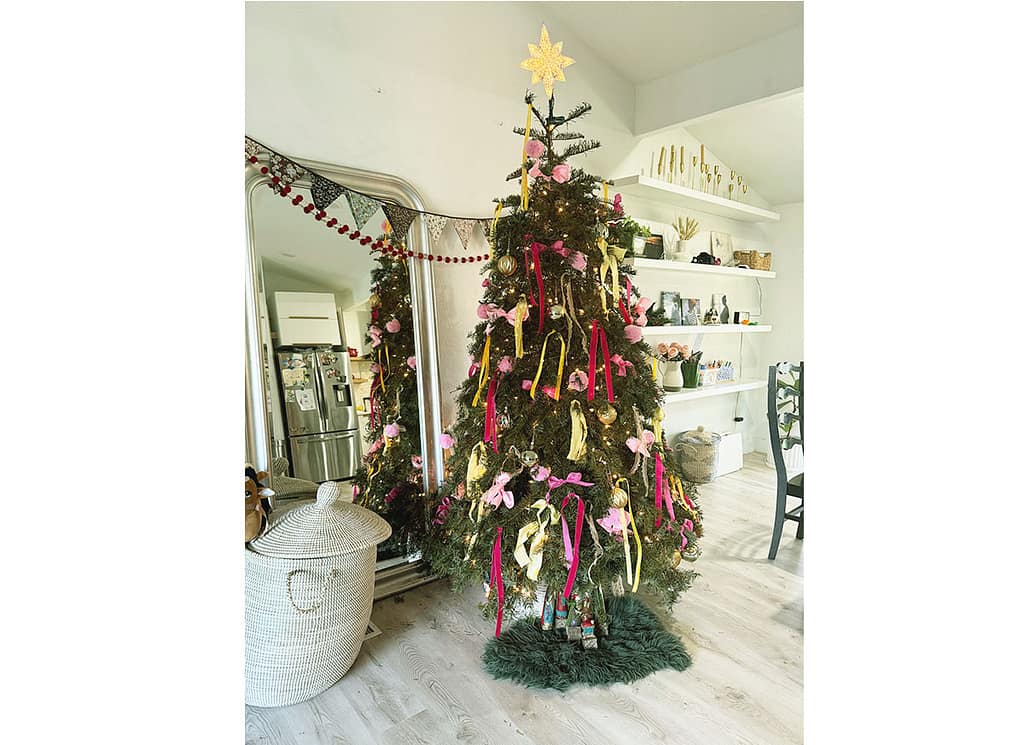 green Christmas tree with yellow and pink ribbon