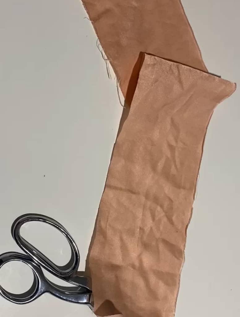 strip of red silk fabric with scissors