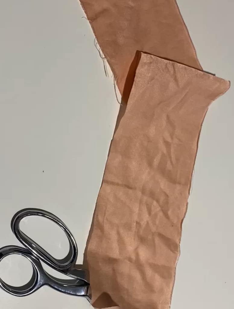 strip of red silk fabric with scissors