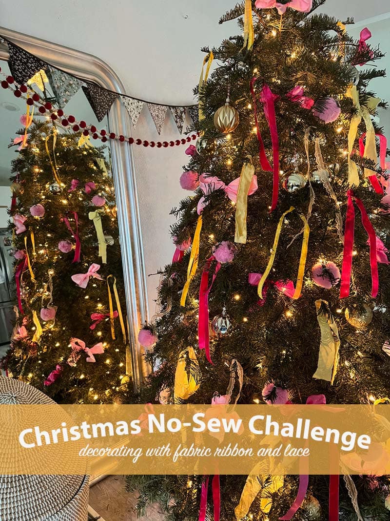 green Christmas tree with yellow and pink ribbons in front of mirror